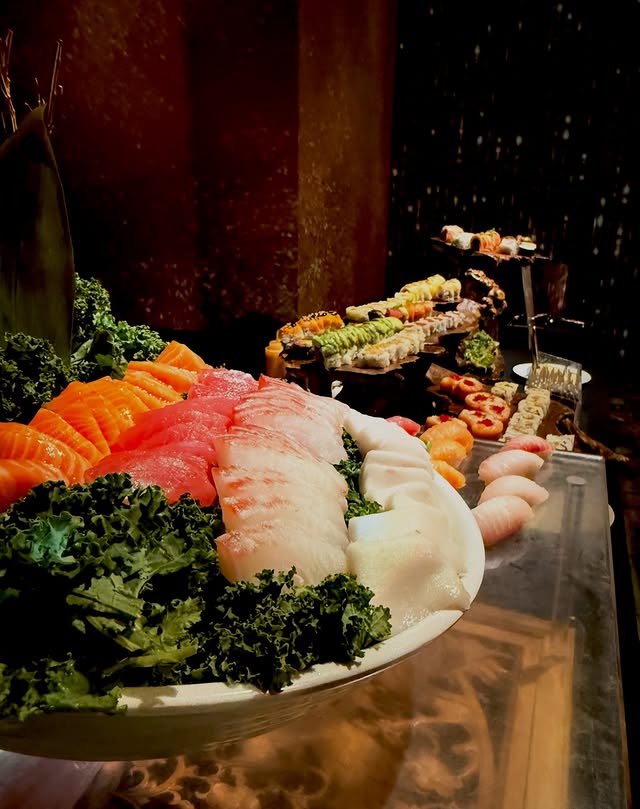 Sashimi and sushi platter at an elegant New York event with dramatic lighting