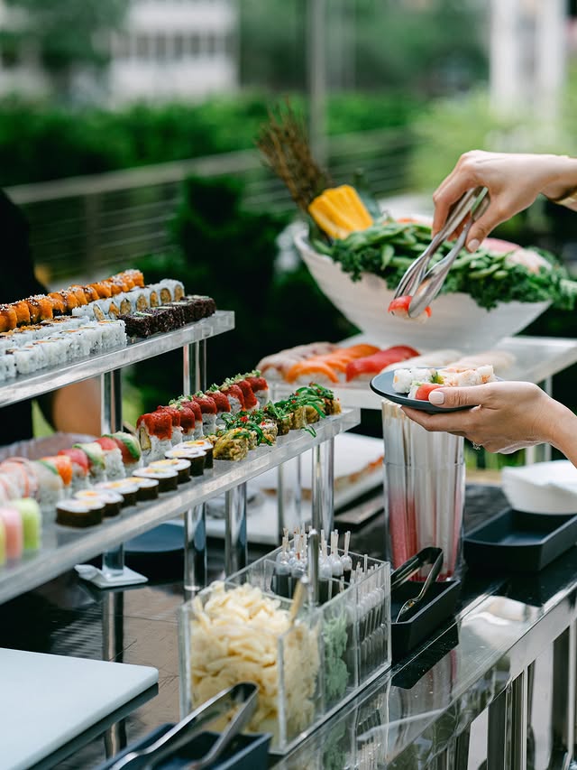 Outdoor sushi station at a private garden party in New York with guests serving themselves